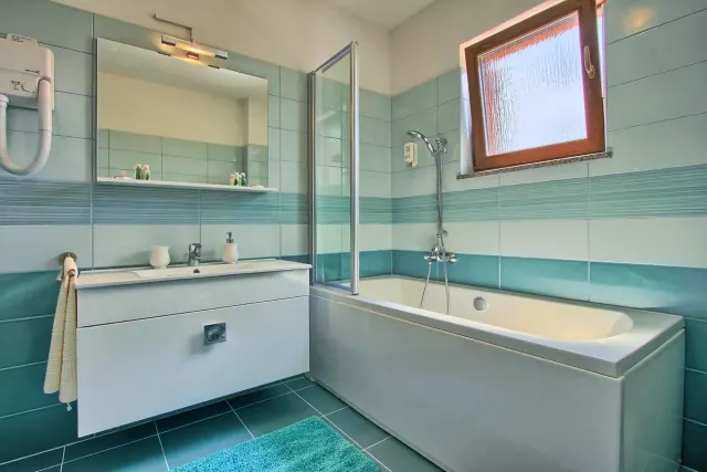 BookNoFees : location de vacances à Štokovci, Croatie – une salle de bains avec une baignoire, un lavabo et un miroir à la Villa Stokovci, à Štokovci