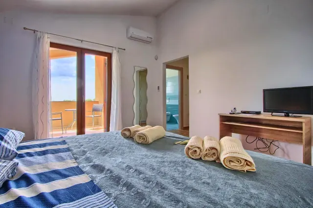 BookNoFees : location de vacances à Štokovci, Croatie – une chambre avec un lit, des serviettes et un piano à la Villa Stokovci, à Štokovci