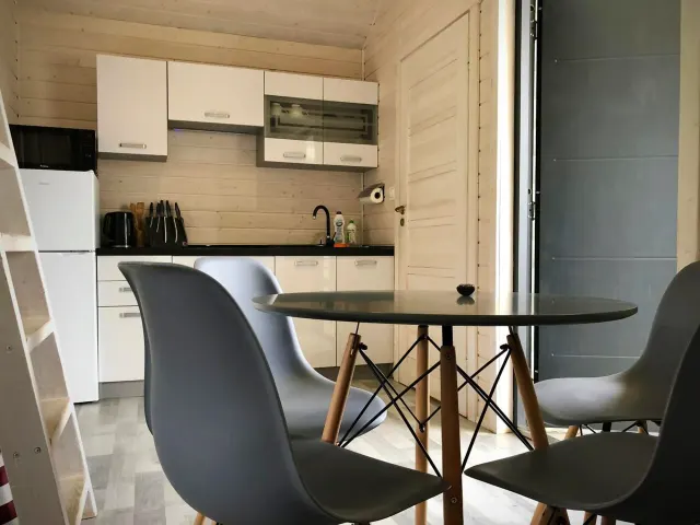 BookNoFees : location de vacances à Jarosławiec, Pologne – une petite cuisine avec une table et des chaises dans le complexe DOMKI SILVER 2, à Jarosławiec