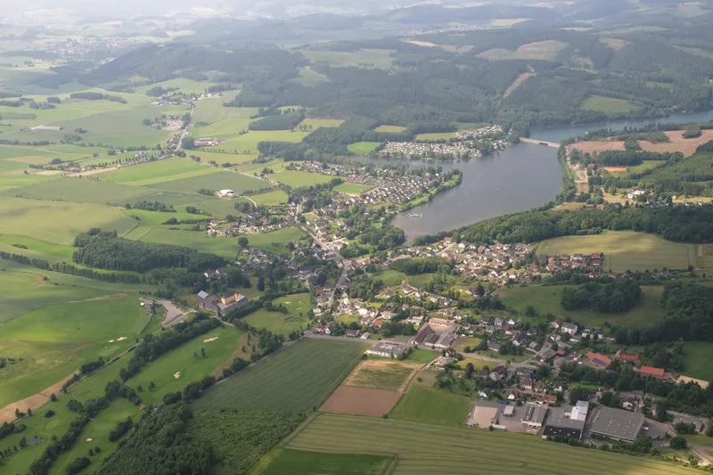 Le lac de Sorpe vu du ciel, avec le village d'Amecke sur sa rive est et les collines boisées du Sauerland qui l'entourent