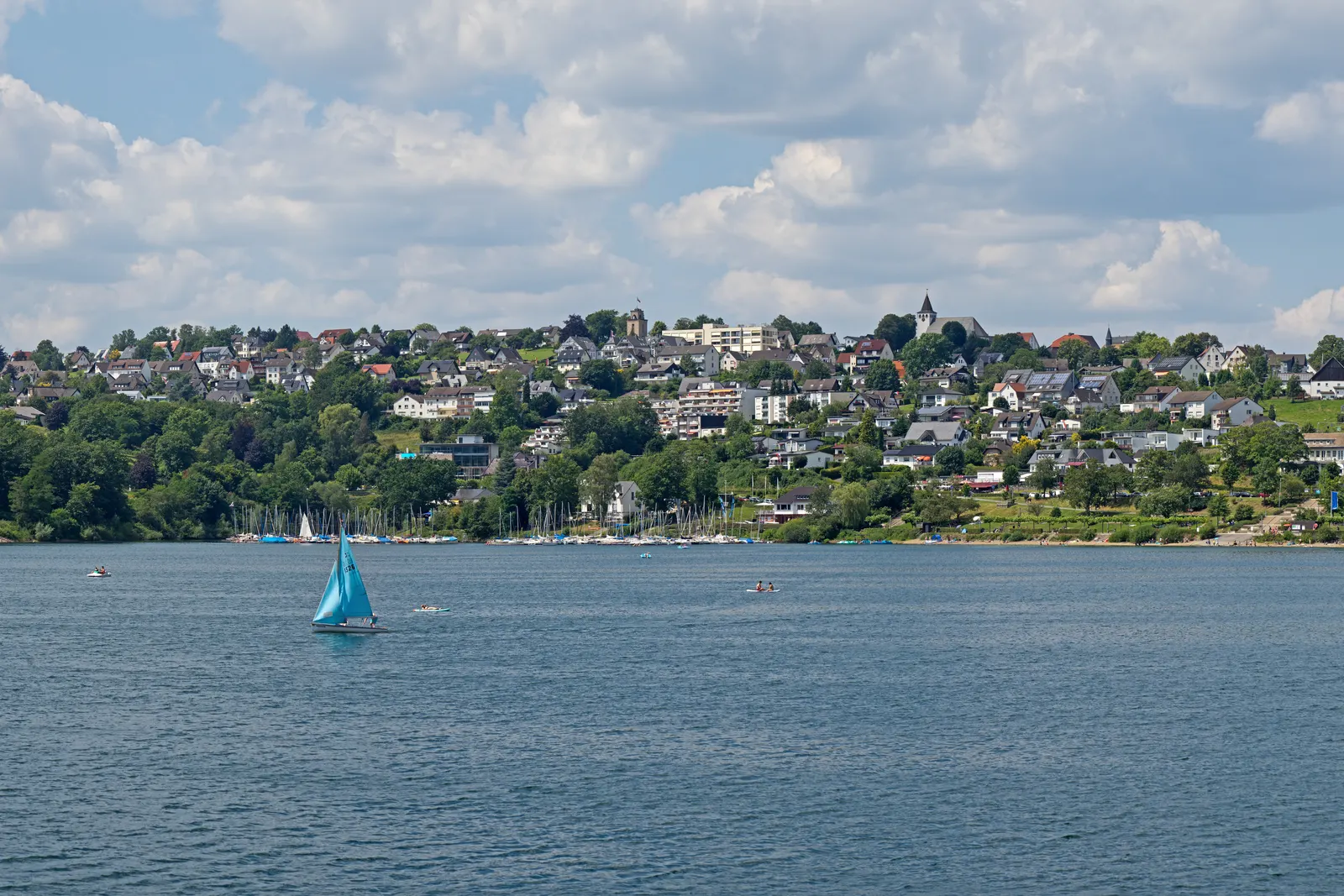 Langscheid, au bord du lac Sorpesee près de Sundern : le village lacustre surplombant le lac, avec un voilier au premier plan