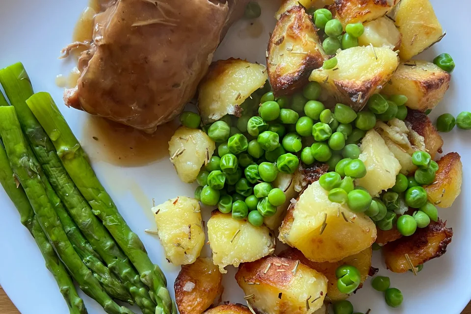 BookNoFees: Photo d’illustration : Rôti de porc avec sauce, pommes de terre rôties, petits pois et asperges