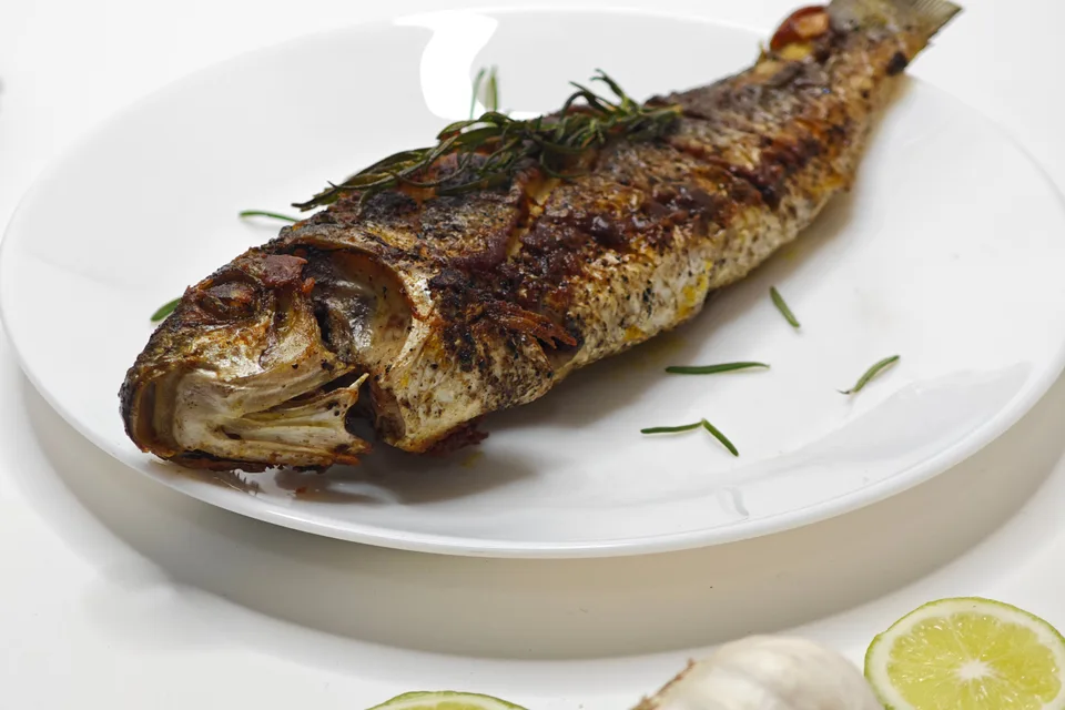 BookNoFees: Photo d’illustration : Poisson entier grillé sur une assiette blanche