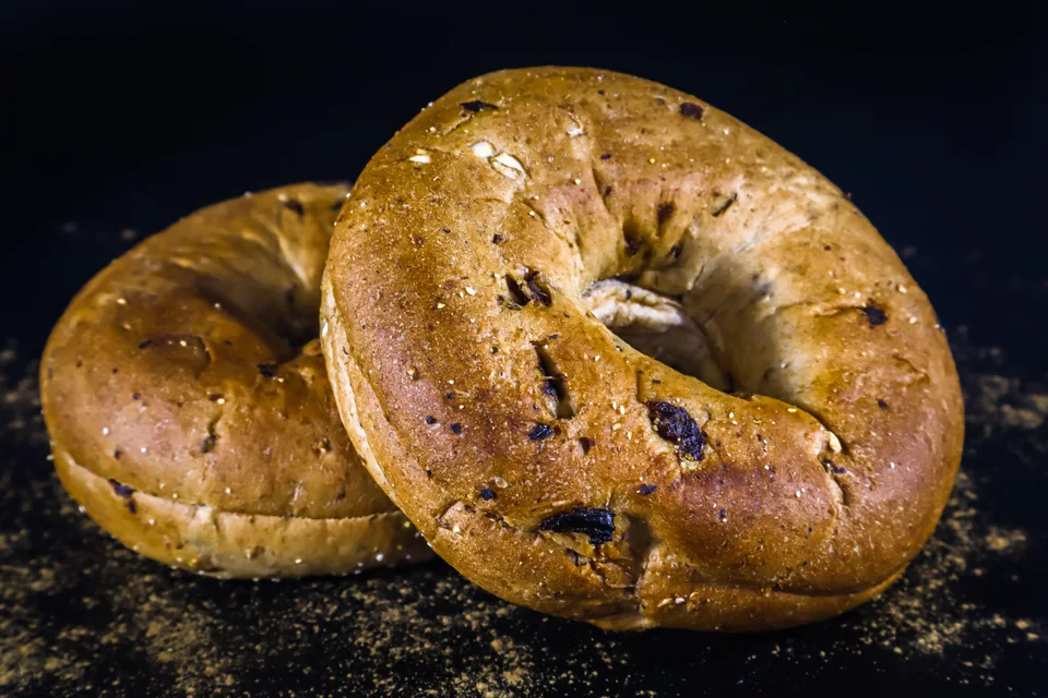 BookNoFees: Photo d’illustration : Deux bagels dorés sur un fond sombre